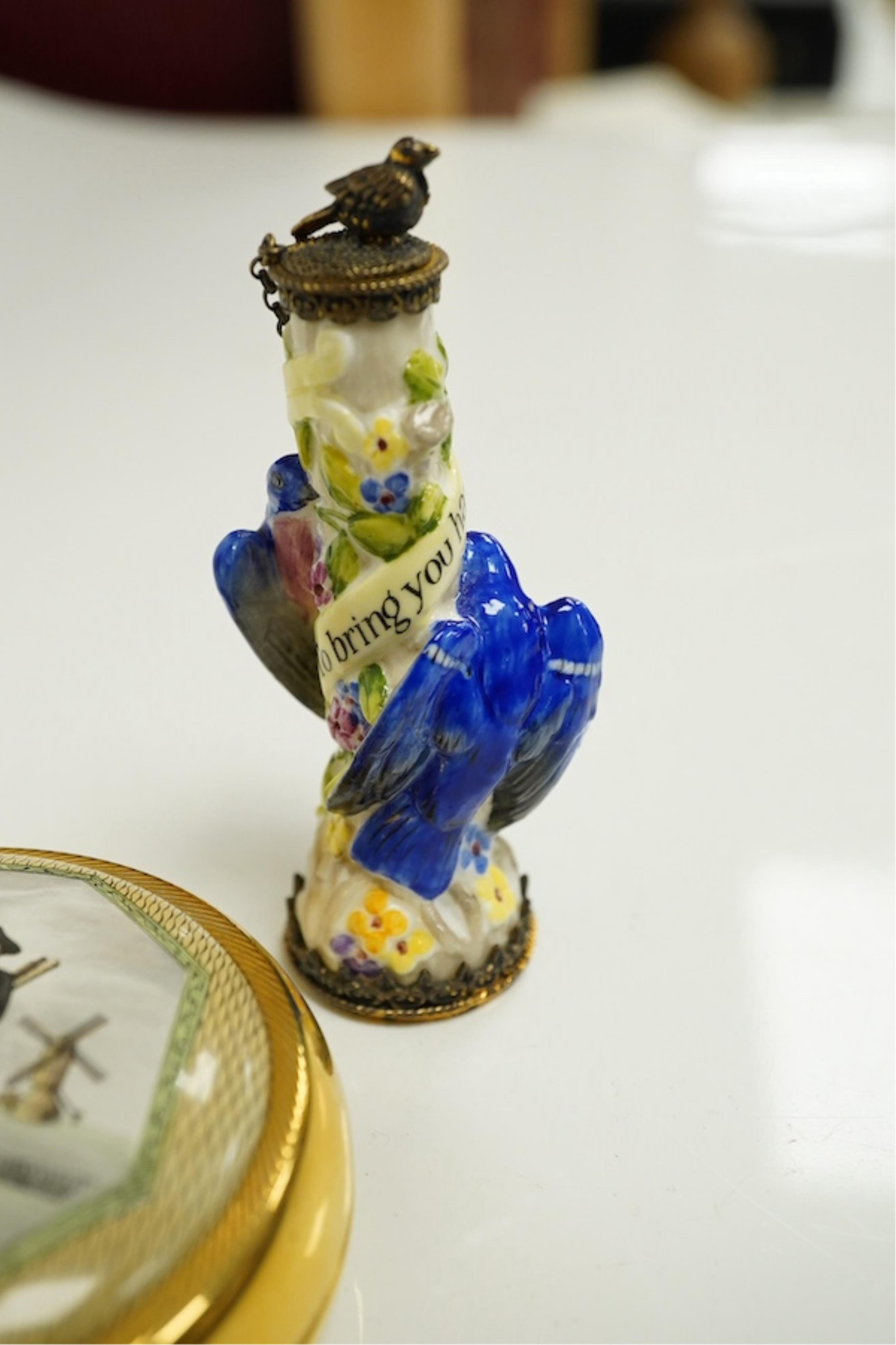 A miniature porcelain egg shaped scent bottle, on chain, two Halcyon Days scent bottles and a circular enamelled paperweight, (4). Condition - fair